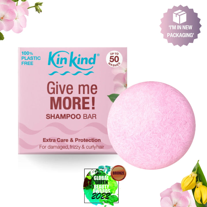 Pink shampoo bar with packaging labeled 'Give me MORE!' for damaged, frizzy and curly hair by Kin Kind on a white background.